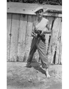 Man Ray Selfportrait, Man Ray facing in front of a fence holding hi...