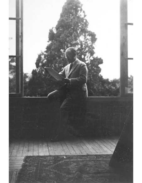 Henri Matisse   sitting by a window, reading a magazine  Henri Matisse