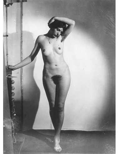 Natacha femme nue en pied main derrière la tête pendentif autour du...